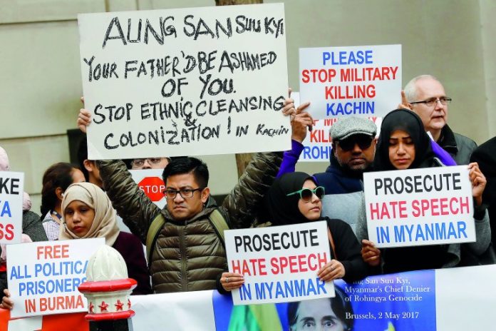 Protesters hold placards as Myanmar's leader Aung San Suu Kyi visits the Guildhall in London where defacto president of Myanmar Aung San Suu Kyi was receiving an award.