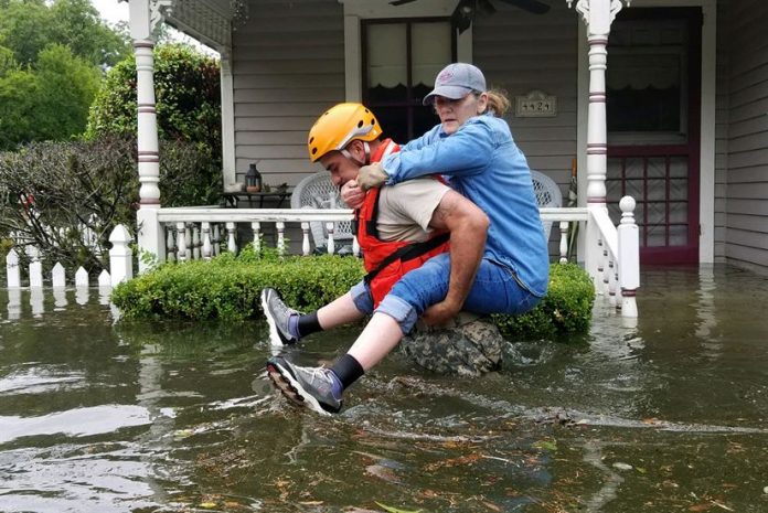 A Texas National Guardsman carries a resident from her flooded home following Hurricane Harvey in Houston
