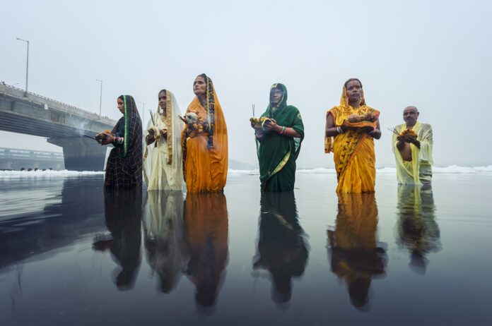 Women pray to the sun in the Yamuna river in northern India in 2019. This year, the ceremony took place in dangerous sludge and more toxic foam.